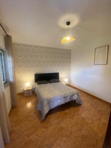 a bedroom with a bed and two lamps in it at Vivenda Carthagena, House Fundão in Fundão