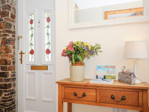 a room with a table with a lamp and flowers on it at Treview in Launceston
