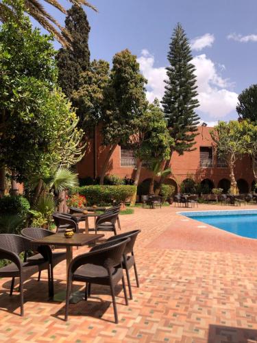 d'une terrasse avec des tables et des chaises à côté de la piscine. dans l'établissement Tiznit Hotel, à Tiznit