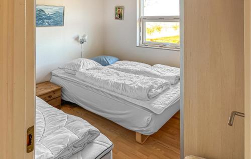 two beds in a room with a window at Three-Bedroom Holiday Home In Orsted in Ørsted