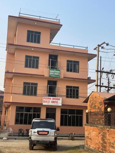 a white truck parked in front of a building at New Buddha Bhoomi Guest House in Lumbini