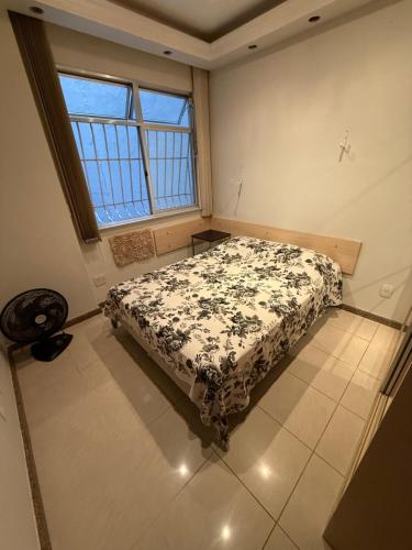 a bedroom with a bed in a room with a window at Quarto Niterói-Ingá in Niterói