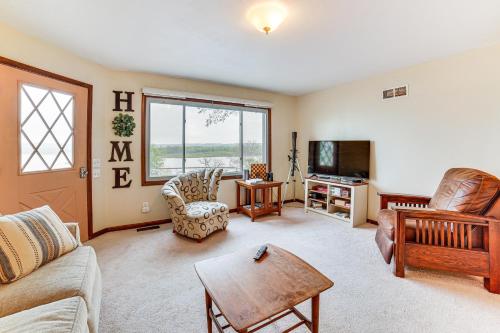 a living room with a couch and a tv at Watch the Sunrise at this Quaint Lake-View Cottage in Peoria