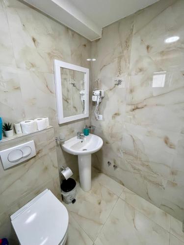 a bathroom with a white sink and a toilet at Villa Festim Ksamil in Ksamil