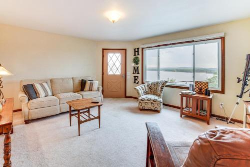 a living room with a couch and a table at Watch the Sunrise at this Quaint Lake-View Cottage in Peoria