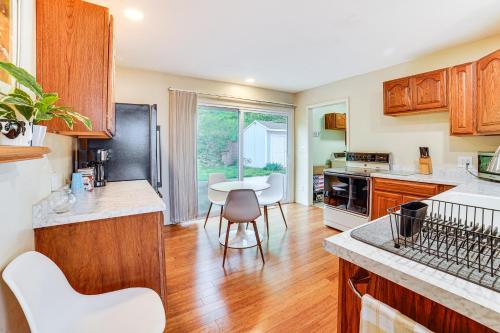 a kitchen with wooden cabinets and a table and chairs at Watch the Sunrise at this Quaint Lake-View Cottage in Peoria