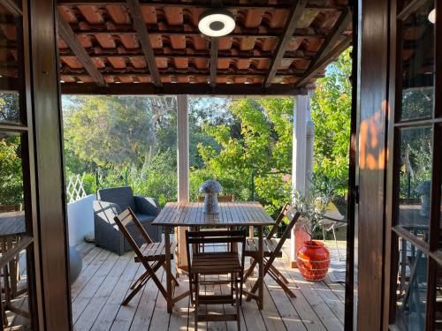 - une véranda avec une table et des chaises en bois dans l'établissement Joli studio maisonnette à 100m de la plage, à Porticcio