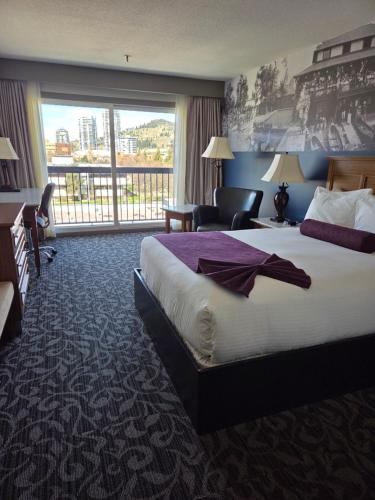 a hotel room with a large bed and a large window at The Royal Anne Hotel in Kelowna