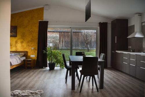 Una cocina y un comedor con mesa y sillas. en Bungalov Vlnka, en Vlachy