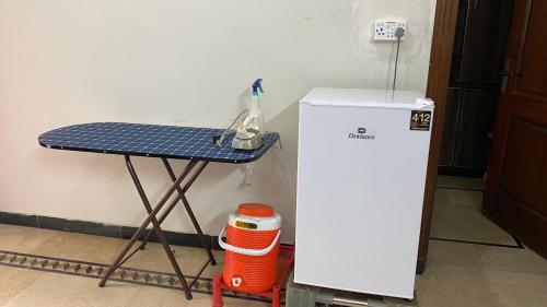 イスラマバードにあるRoyal blue boys hostelのテーブルと冷蔵庫の隣にあるテーブル