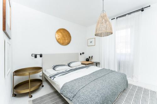 a white bedroom with a bed and a chair at Private house with garden in Nový Jáchymov