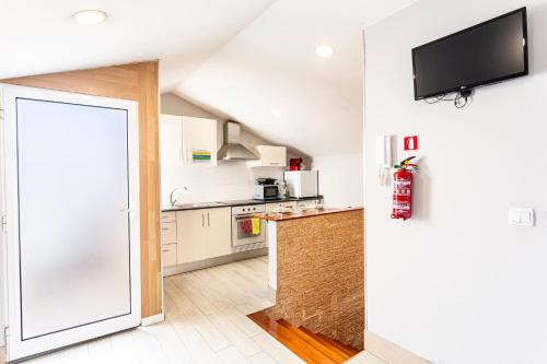 a kitchen with white cabinets and a flat screen tv at Holiday Home Funchal Center in Funchal