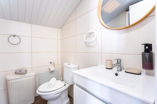 a white bathroom with a toilet and a mirror at Holiday Home Funchal Center in Funchal
