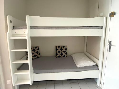 Ce lit superposé se trouve dans une petite chambre. dans l'établissement LE SOUEHLA APPART - Piscine Wifi Parking résidence les Sables D'or - La Grande Motte, à La Grande Motte