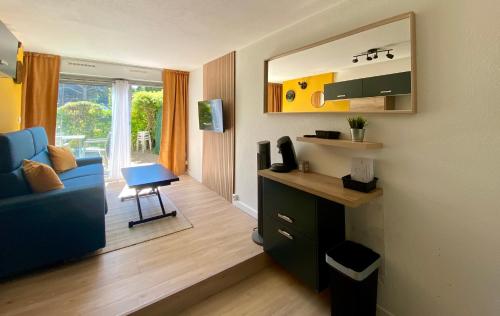 un salon avec un canapé bleu et une fenêtre dans l'établissement LE SOUEHLA APPART - Piscine Wifi Parking résidence les Sables D'or - La Grande Motte, à La Grande Motte