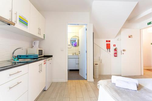 a kitchen with white cabinets and a sink at Holiday Home Funchal Center in Funchal