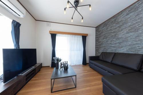a living room with a couch and a tv at Sakura in Tokyo