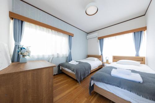 a hotel room with two beds and a desk at Sakura in Tokyo