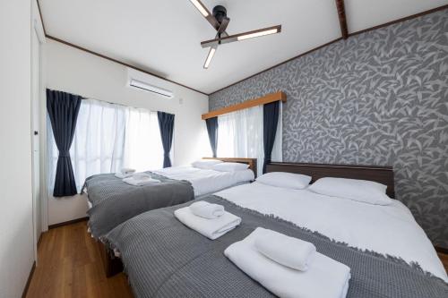 a bedroom with two beds with white towels on them at Sakura in Tokyo