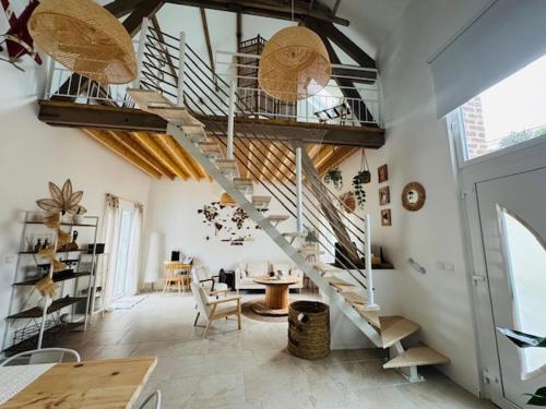 a living room with a spiral staircase in a building at Le Gite de l Ancre in Ville-sur-Ancre