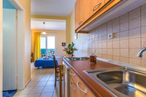 a kitchen with a stainless steel sink and a living room at Atlantis in Plakias