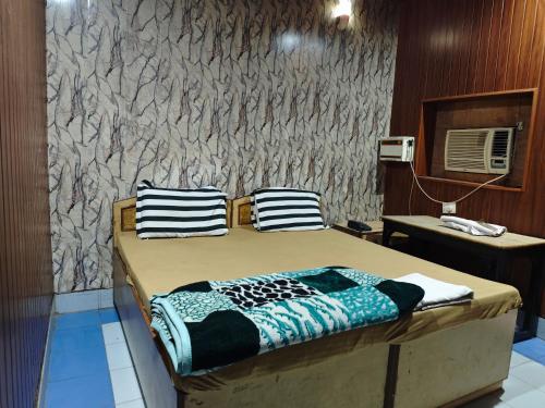 a bed with two pillows on it in a room at Raj Hotel - Since 1960 in Sultānpur