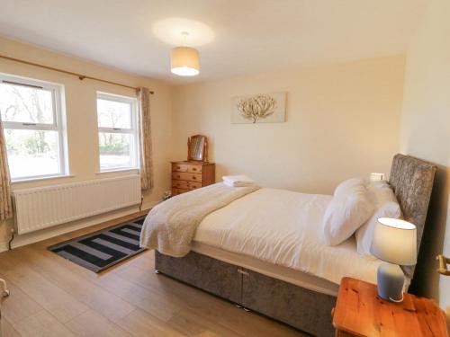 ein Schlafzimmer mit einem großen Bett und zwei Fenstern in der Unterkunft Hill House in Ballymoney