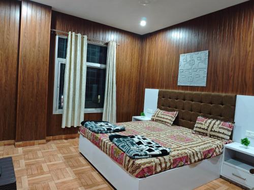 a bedroom with a bed and wooden walls at Raj Hotel - Since 1960 in Sultānpur