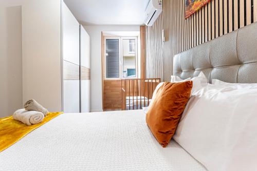 a bedroom with a white bed with an orange pillow at Holiday Home Funchal Center in Funchal