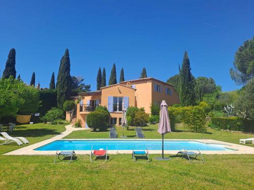 a villa with a swimming pool in front of a house at Magnifique Villa avec piscine in Cadenet