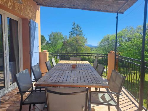 a wooden table and chairs on a patio at Magnifique Villa avec piscine in Cadenet