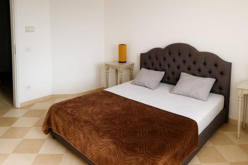 a bedroom with a large bed with a wooden headboard at résidence Nesrine-Hammemet sud in Hammamet