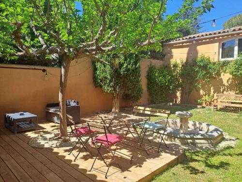 a patio with chairs and a tree and a fountain at Magnifique Villa avec piscine in Cadenet