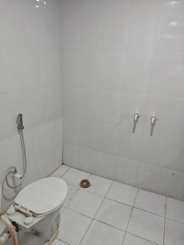 a white bathroom with a toilet and a shower at Raj Hotel - Since 1960 in Sultānpur