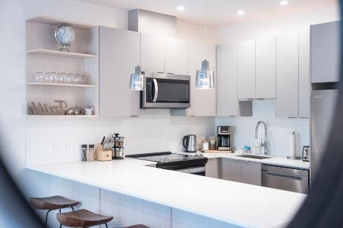 a kitchen with white cabinets and a white counter top at Mountainside Revival by Revelstoke Vacations in Revelstoke