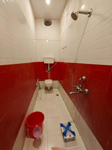 a bathroom with a toilet and a red and white wall at Raj Hotel - Since 1960 in Sultānpur