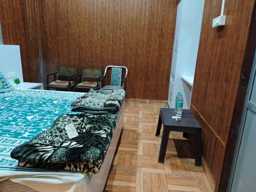 a small room with two beds and a table at Raj Hotel - Since 1960 in Sultānpur