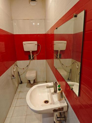 a bathroom with a sink and a toilet and a mirror at Raj Hotel - Since 1960 in Sultānpur