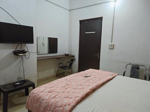 a bedroom with a bed and a desk and a television at Raj Hotel - Since 1960 in Sultānpur
