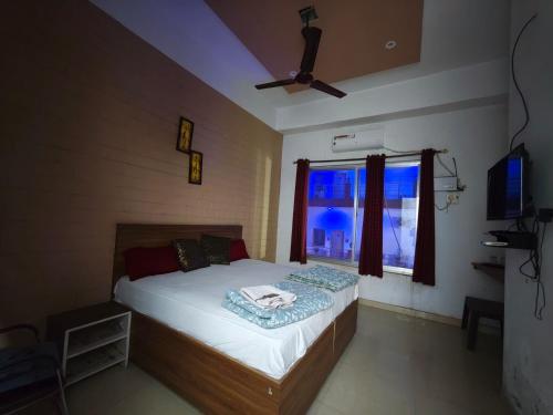 a bedroom with a bed with a window and a fan at Raj Hotel - Since 1960 in Sultānpur