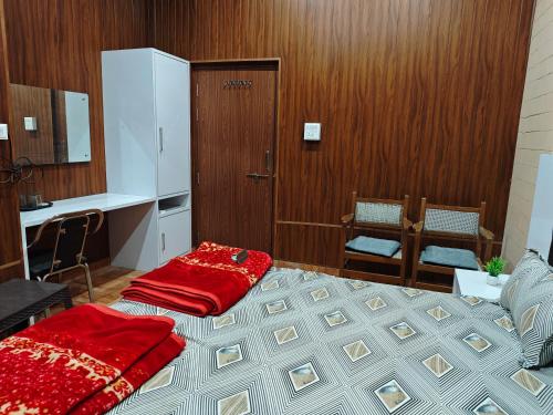 a bedroom with a bed with a red blanket on it at Raj Hotel - Since 1960 in Sultānpur