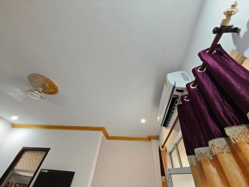 a staircase in a room with purple curtains at Raj Hotel - Since 1960 in Sultānpur