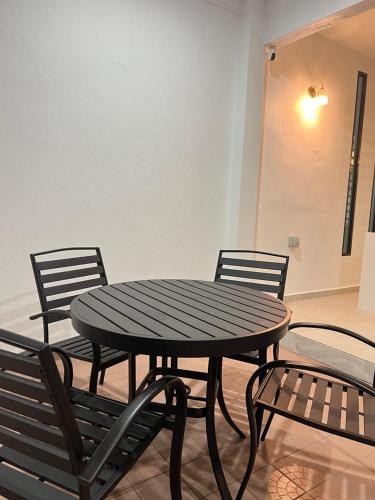 a black table and chairs with a table and two chairs at BungalowD Pool Villa 7R6B with Netflix Great Movies & Dramas in Ipoh