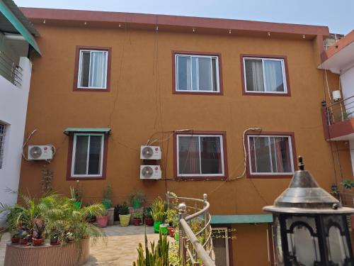 a building with windows and plants in front of it at Raj Hotel - Since 1960 in Sultānpur