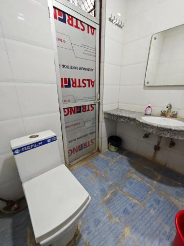 a bathroom with a toilet and a sink at Raj Hotel - Since 1960 in Sultānpur