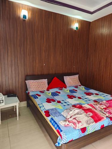 a bedroom with a bed with a wooden wall at Raj Hotel - Since 1960 in Sultānpur