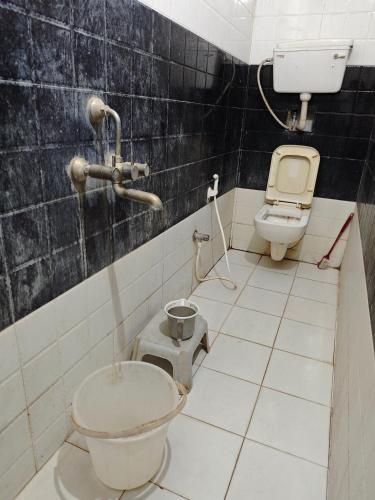 a dirty bathroom with a toilet and a sink at Raj Hotel - Since 1960 in Sultānpur