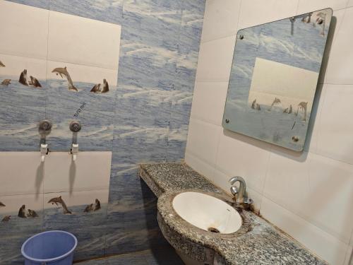 a bathroom with a sink and a mirror and seals at Raj Hotel - Since 1960 in Sultānpur