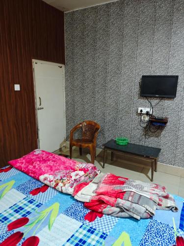 a bedroom with a bed and a table and a tv at Raj Hotel - Since 1960 in Sultānpur