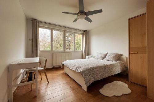 une chambre avec un lit et un ventilateur de plafond dans l'établissement Quiet 3 bedrooms apt, 30 min from Paris centre, à Bagnolet